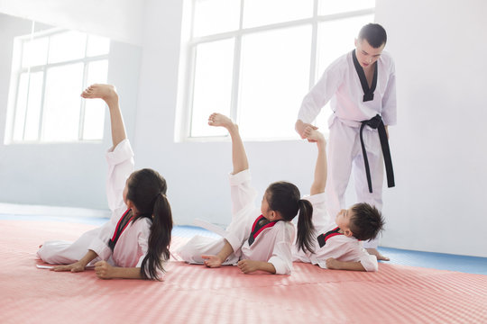 Young instructor teaching children Tae Kwon Do