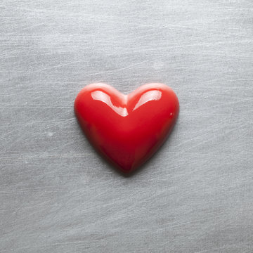 Red heart on a scratched metal plate