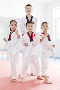 Young instructor teaching children Tae Kwon Do
