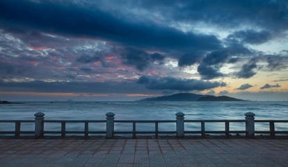 Fototapeta na wymiar A colourful cloudy morning sky over the south china sea and islands of the coast of Nha Trang central Vietnam.