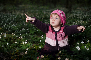 beautiful little girl in forest on flowers field