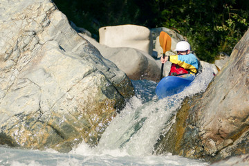 Extreme Kayaker Going Over Rocky Waterfall Drop in Raging River Rapids