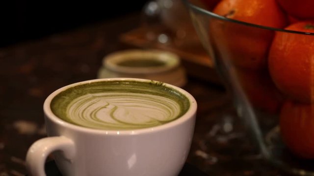 Close-up of cup of latte matcha coffee, spining loop