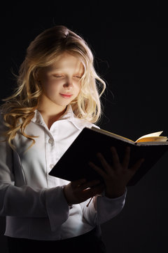 photo of young girl reading book