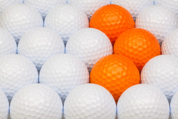 White and orange golf balls in the box