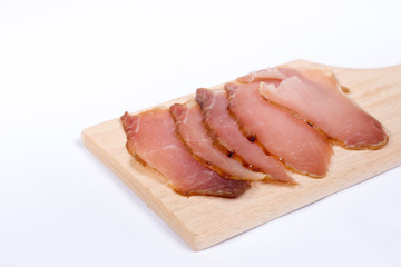 Sliced smoked sirloin on the wooden board with copy space