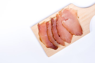 Sliced smoked sirloin on the wooden board with copy space