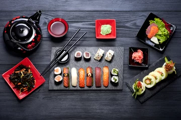 Keuken spatwand met foto Sushi ingesteld op zwarte achtergrond bovenaanzicht © nioloxs