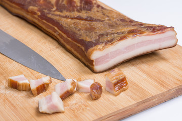 Whole smoked bacon on the wooden board