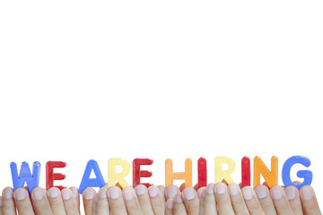 Man fingers showing "WE ARE HIRING" text on white background