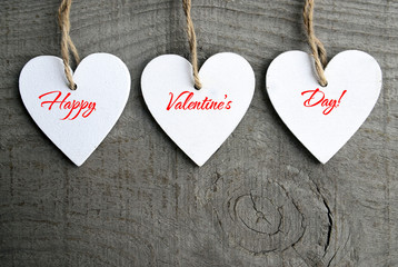 Happy Valentines Day background. Decorative white wooden hearts on grey rustic wooden background with copy space.Selective focus.Winter holidays,Valentine's Day concept.