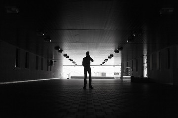 Dark silhouette of a man making an anonymous phone call
