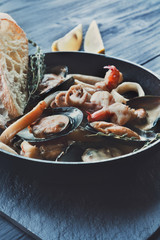 Seafood Stew in Saucepan on dark wood background