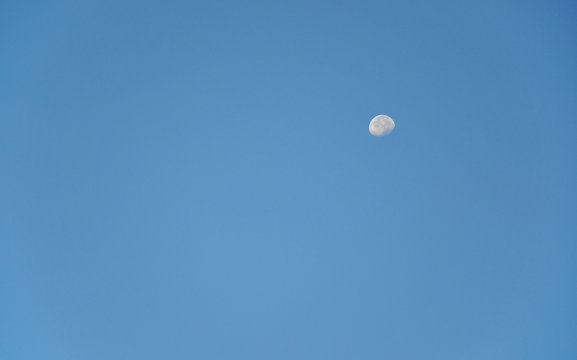 Day moon in blue sky