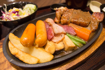 Grilled sausages vegetables in a pan grill on the table