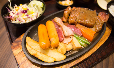 Grilled sausages vegetables in a pan grill on the table