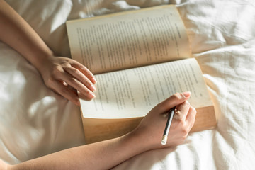 Woman read a book on bed , selective focus - Powered by Adobe