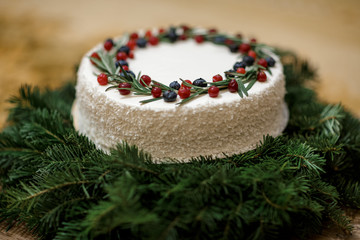 Christmas cake with berries on the background of fir branches