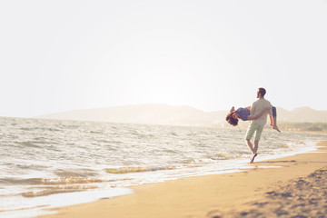 happy couple running on the beach