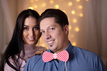 Funny couple playing with fake bowtie