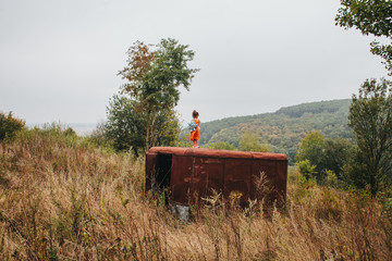 Obraz premium little girl stands on the old trailer in the woods
