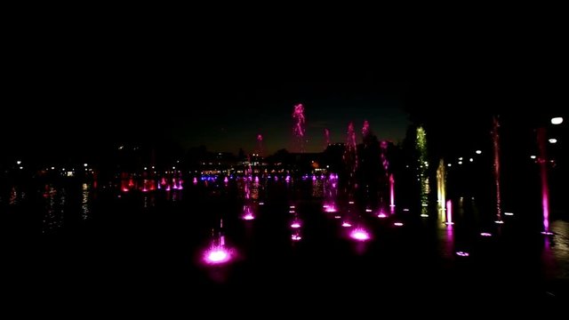 Colorfully lit fountain in a park at night