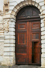 Fototapeta na wymiar Open old medieval style broun wooden door on classic facade building in Lviv Ukraine