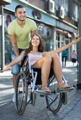 Naklejka premium Girl in wheelchair with friend outdoor