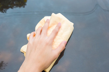 Close up of Hand Washing Car with Yellow Chamois (microfiber towel) - Cleaning Concept