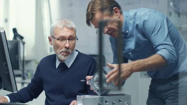 Two Senior Engineers Discuss Important Technical Component. Both are Experienced and Wise. Their Office Looks Modern and Bright. Shot on RED Cinema Camera in 4K (UHD). 