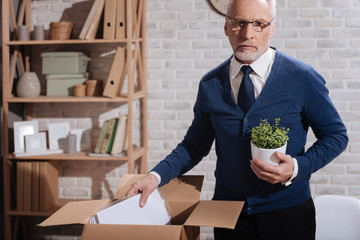 Hopeless professional clearing his workplace