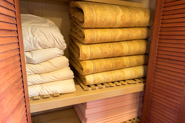 Obraz na płótnie Canvas Stacked of bedsheets and blankets in a wardrobe