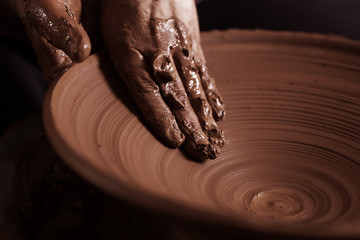 Potter shaping clay on the pottery wheel