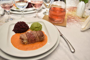 Pork steak filled with cheese wrapped in bacon with red cabbage and smashed peas