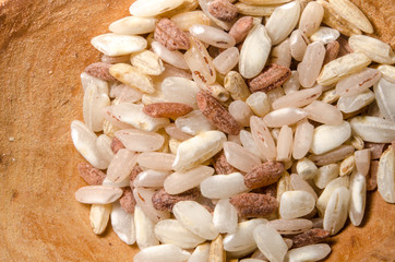 Mix of different rice types rose, wild, brown, arborio in the wooden spoon. Closeup macro shot.