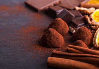 Delicious chocolates and spices on a black background.