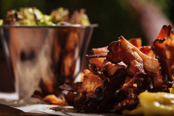 Close up of fried bacon standing on a wooden tray