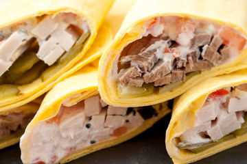 Various of tasty tortilla wraps on dark slate. Healthy street food