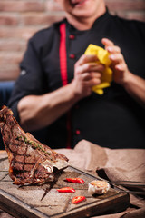 Close up of steak and a man standing in restaurant