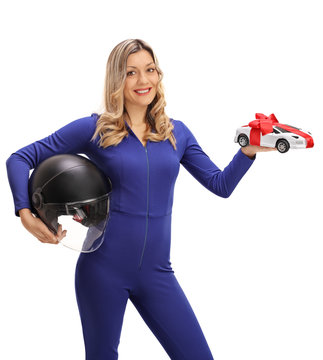 Happy female car racer holding helmet and model car