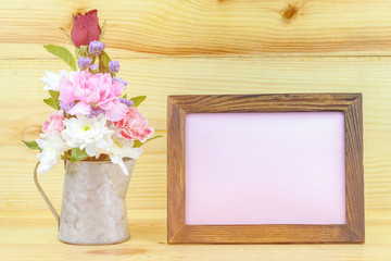 photo frame and flowers on wooden background