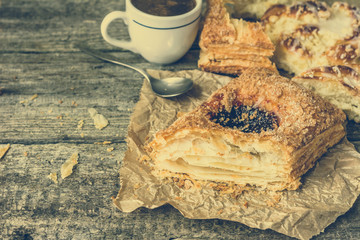 Fattening breakfast - french pastry, sweet bun and coffee cup on wooden table