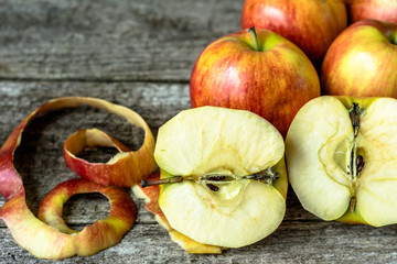 Whole apples and cut in half apples on wooden background
