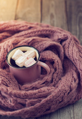  mug with a hot drink and marshmallow, wrapped in a pink scarf
