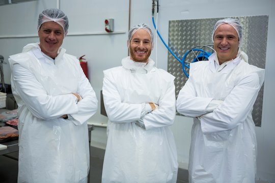Team of butchers standing with arms crossed