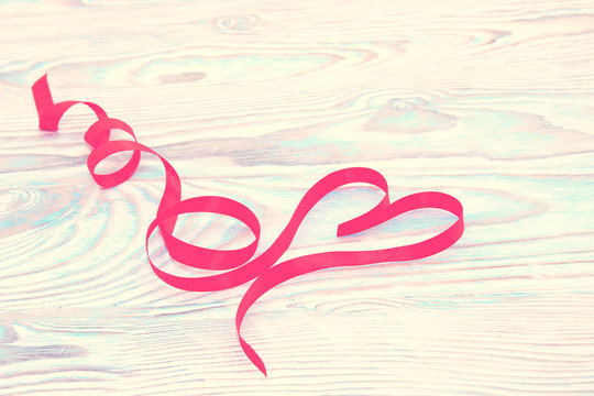Happy Valentines Day. Red Ribbon Heart on a wooden background. Valentines Day concept