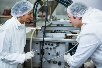 Technicians examining meat processing machine