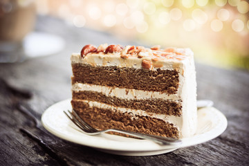 Coffee cake with almond on white plate in coffee shop.