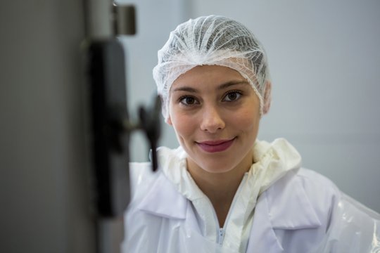 Female butcher smiling at meat factory