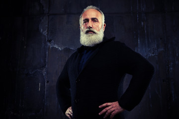 Bearded male looking seriously against black background